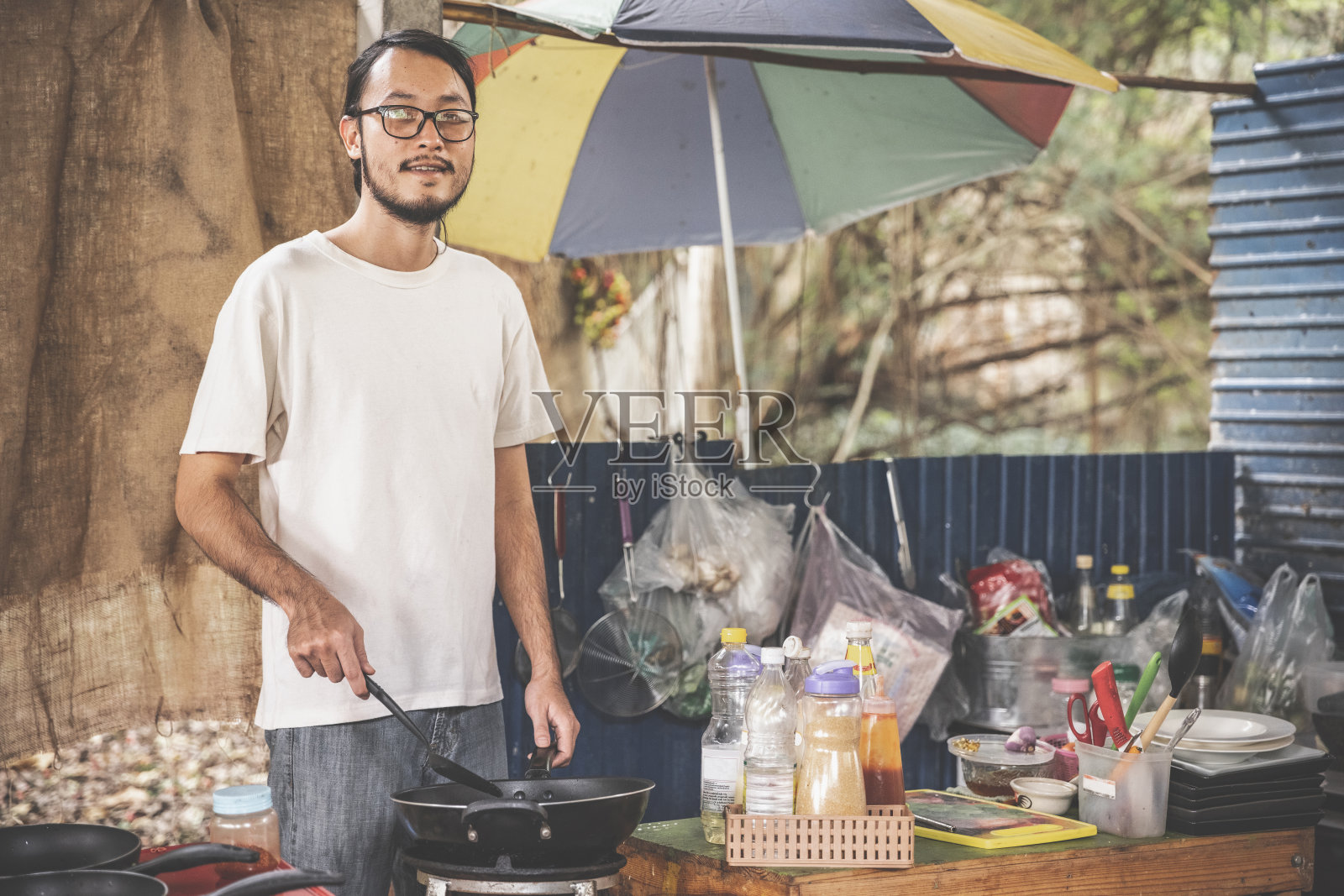 亚洲男人在传统的街头餐馆做饭。肖像。照片摄影图片