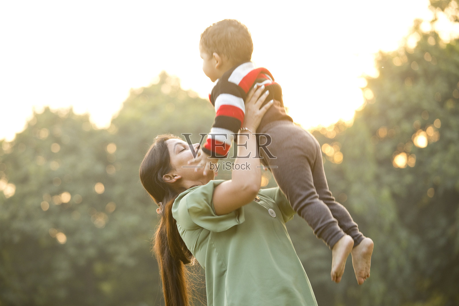 母亲抱着儿子在公园里照片摄影图片