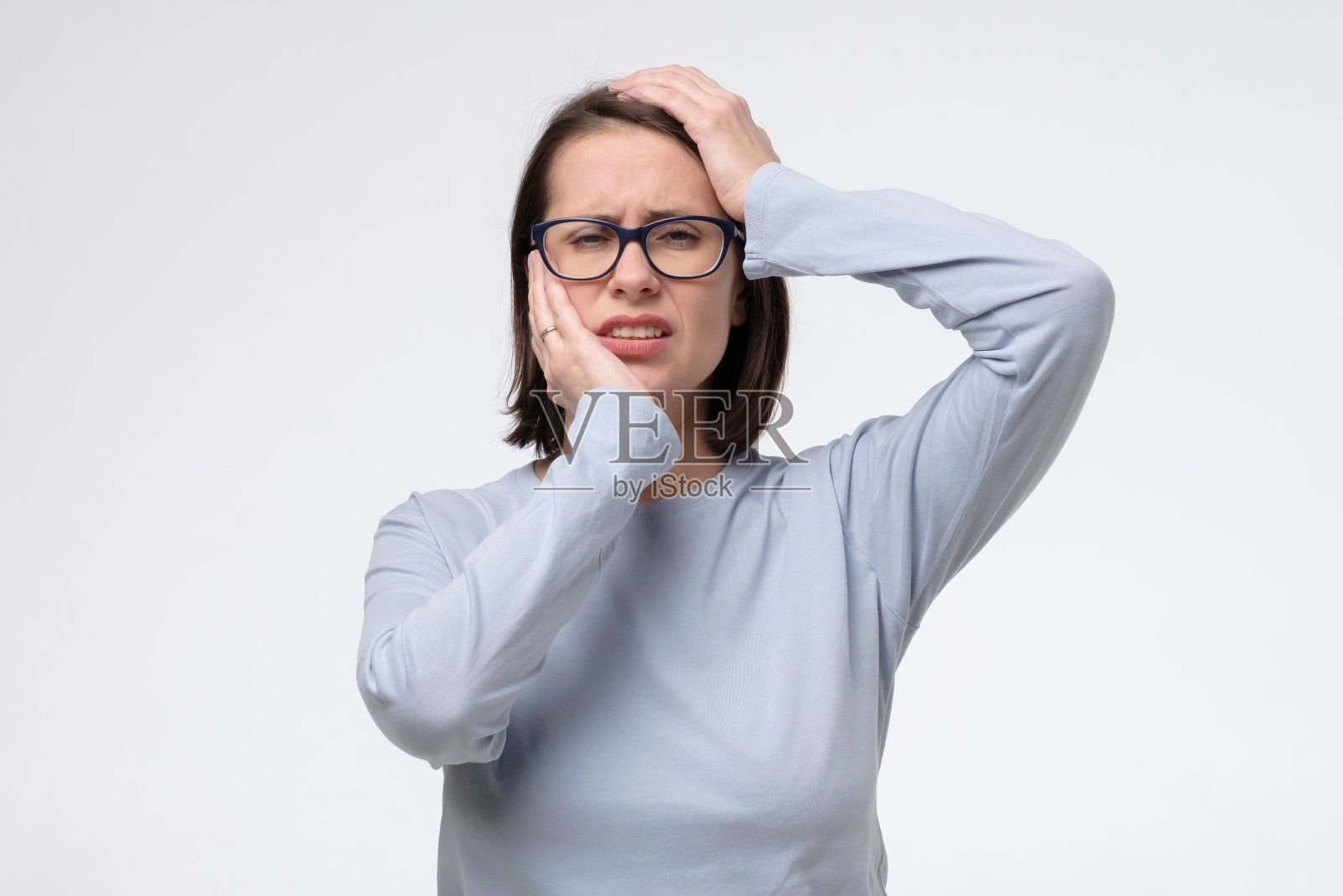 成熟的白人妇女有一个可怕的头痛，孤立在白墙上。照片摄影图片