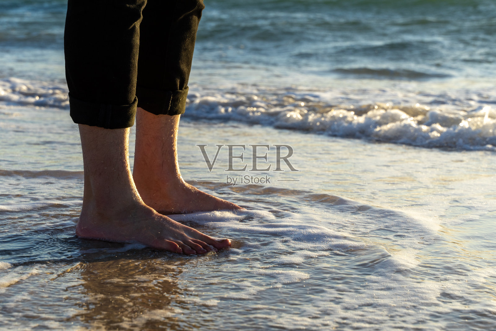 海浪和青年的光脚照片摄影图片