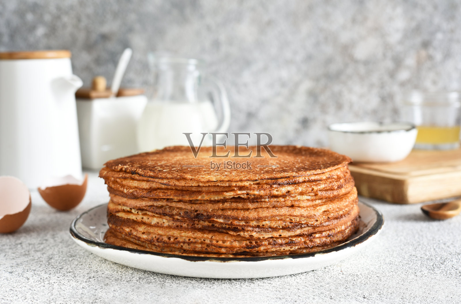 在明亮的背景下，早餐盘上的一叠煎饼。早餐是煎饼。照片摄影图片