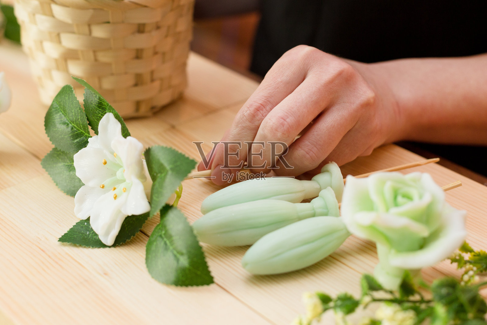 一个女人手里的花朵形状的手工肥皂照片摄影图片
