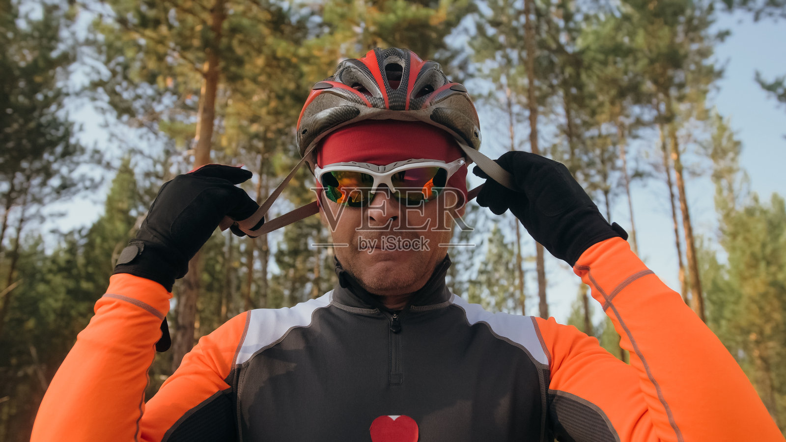 训练运动员溜冰。冬季两项骑轮滑，带滑雪杖，戴头盔。秋季锻炼。辊的运动。运动员准备出发了。照片摄影图片