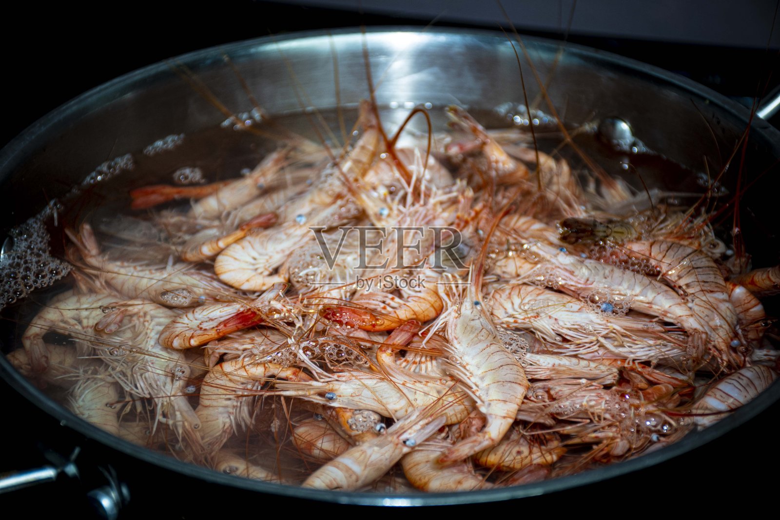 鲜虾虾在沸水锅中烹煮照片摄影图片