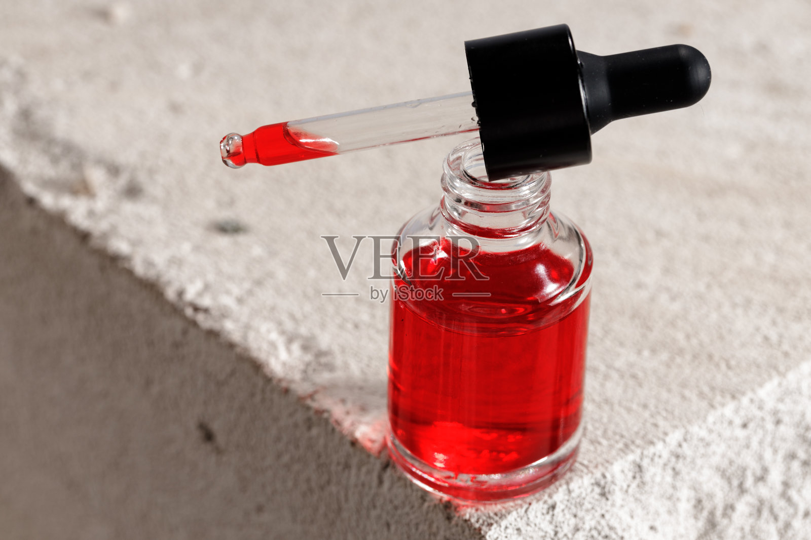 装有化妆油的玻璃瓶放在煤渣砖上照片摄影图片