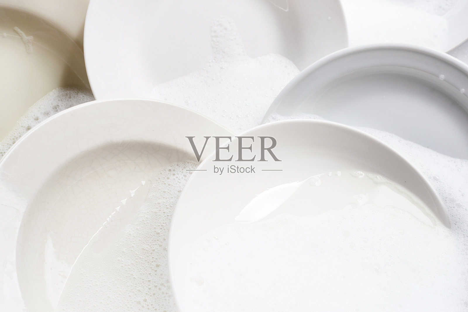 洗碗，厨房水槽里泡着的脏盘子。照片摄影图片