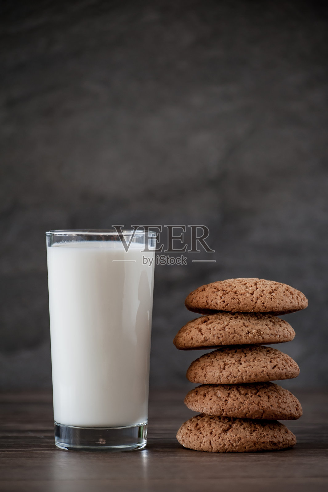 木桌上放着一杯牛奶和燕麦饼干照片摄影图片