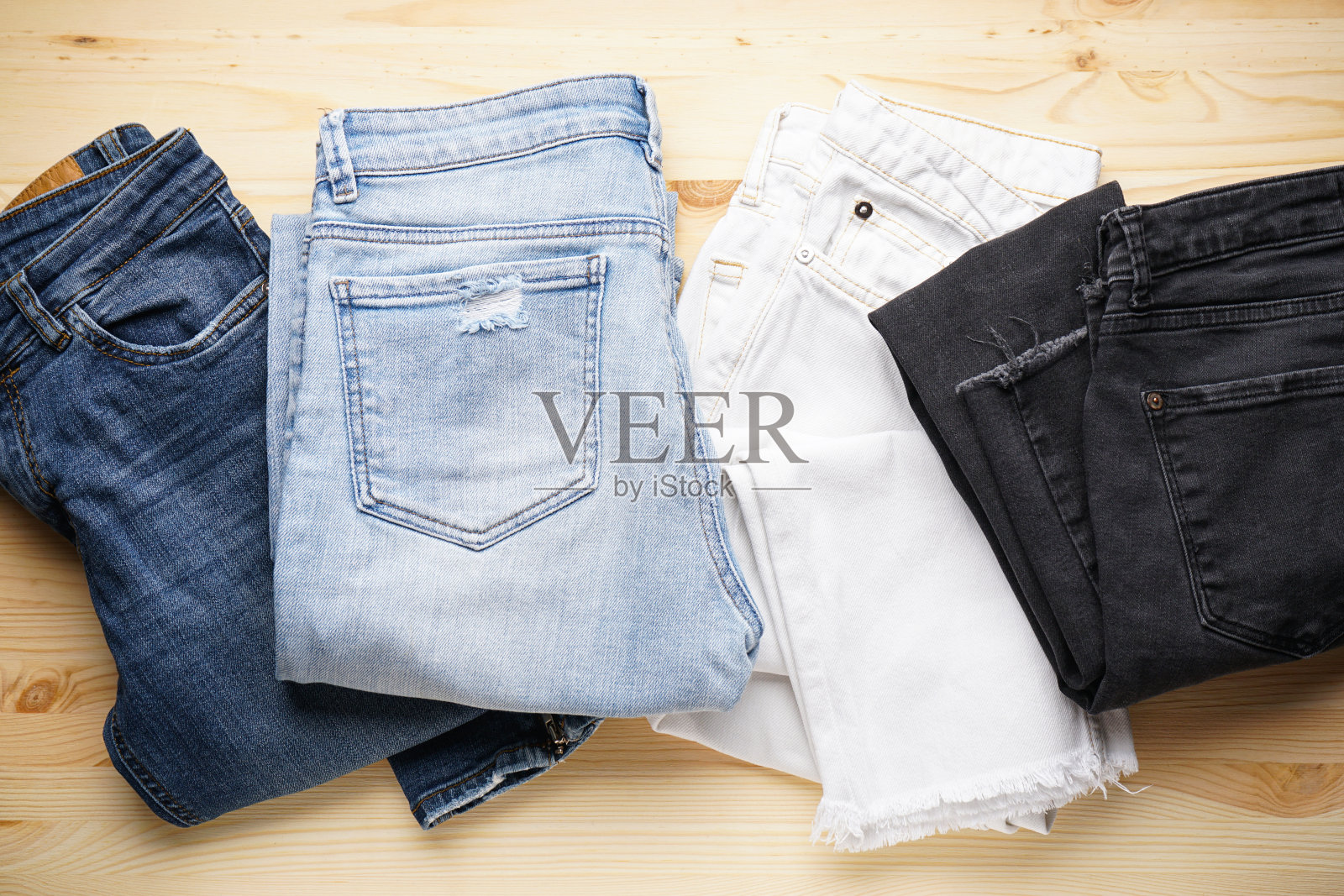 木制背景上的牛仔裤，俯视图。照片摄影图片