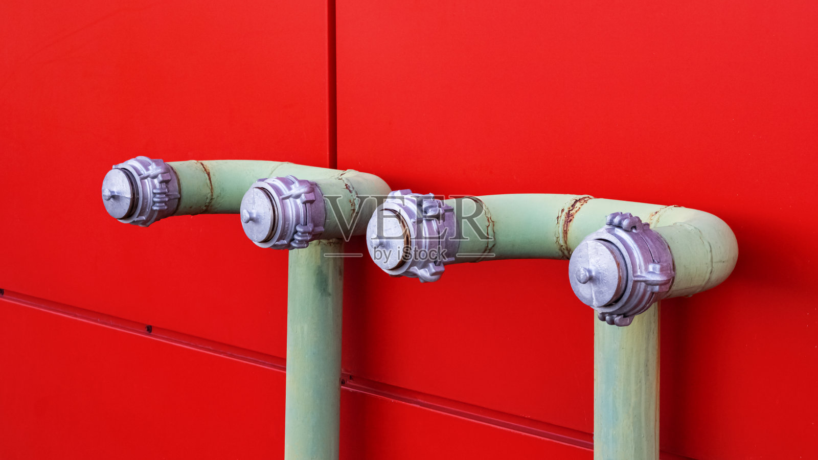 靠近红色墙上的水管照片摄影图片