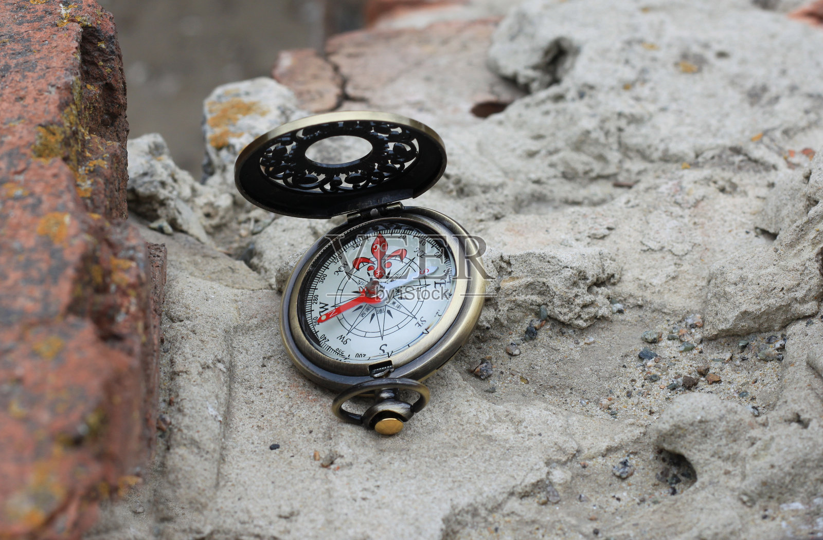 铁制指南针贴在砖墙上，象征旅游用指南针照片摄影图片