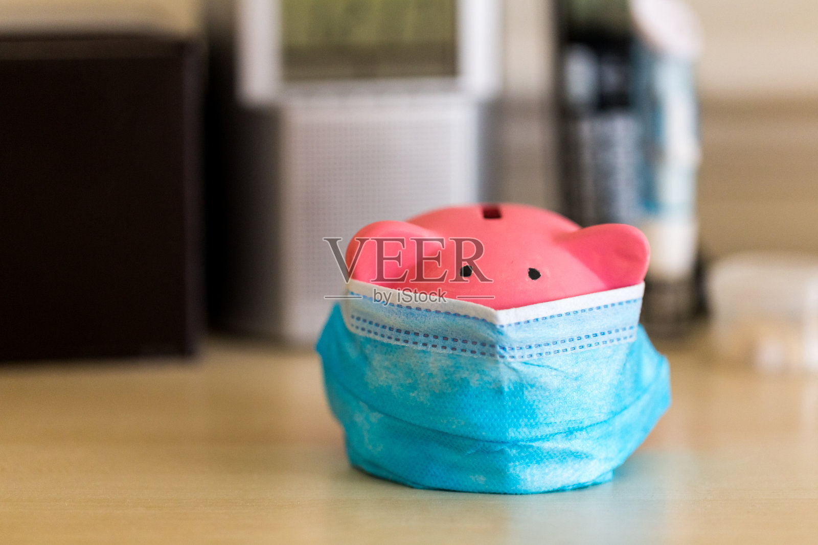 戴着医用口罩存钱，大流行期间以储蓄和经济衰退为主题照片摄影图片