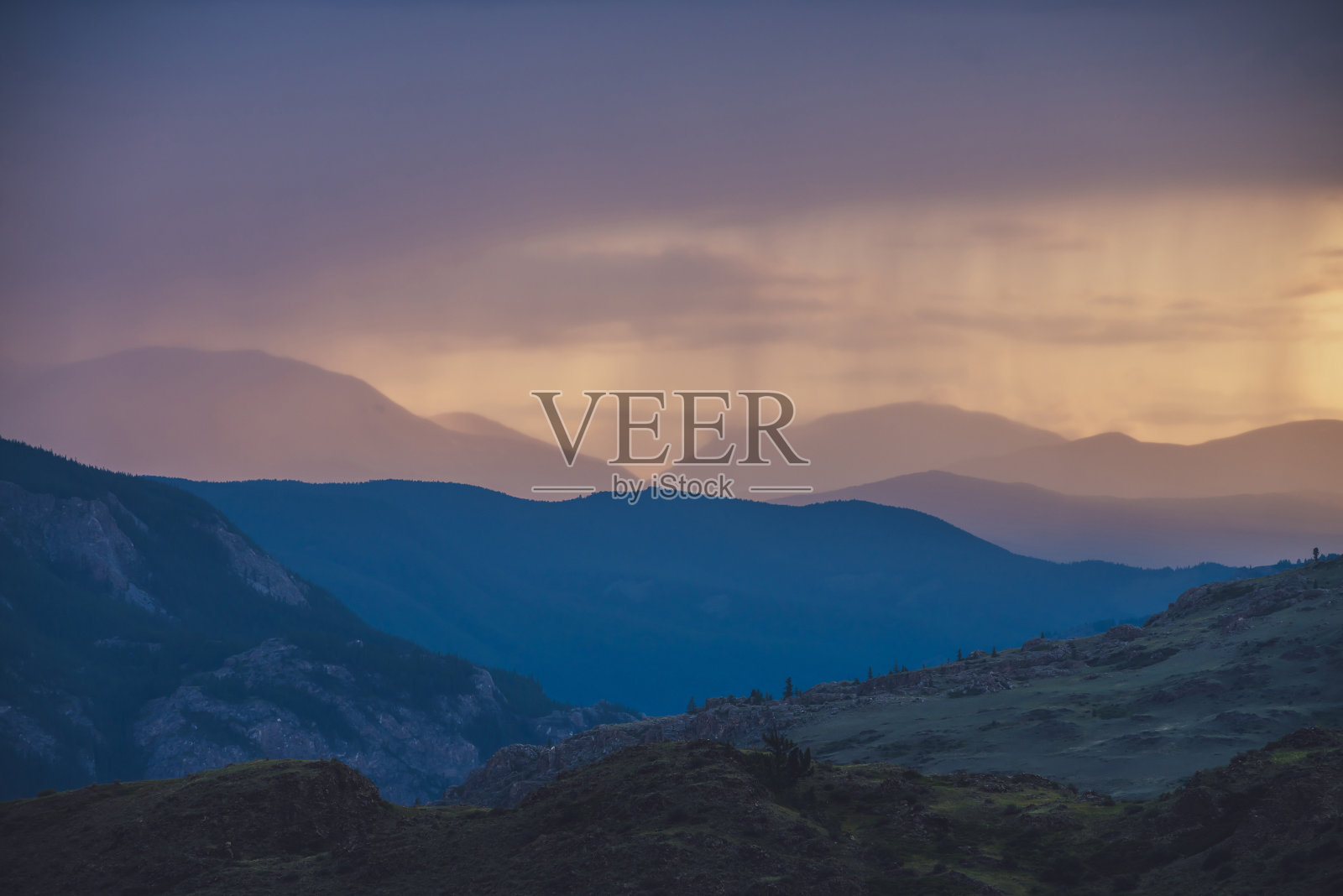 大气景观与剪影的山与树木的背景鲜明的橙色蓝色淡紫色黎明天空。色彩斑斓的自然景色以日出日落为启发性的色彩。日落风景照片摄影图片