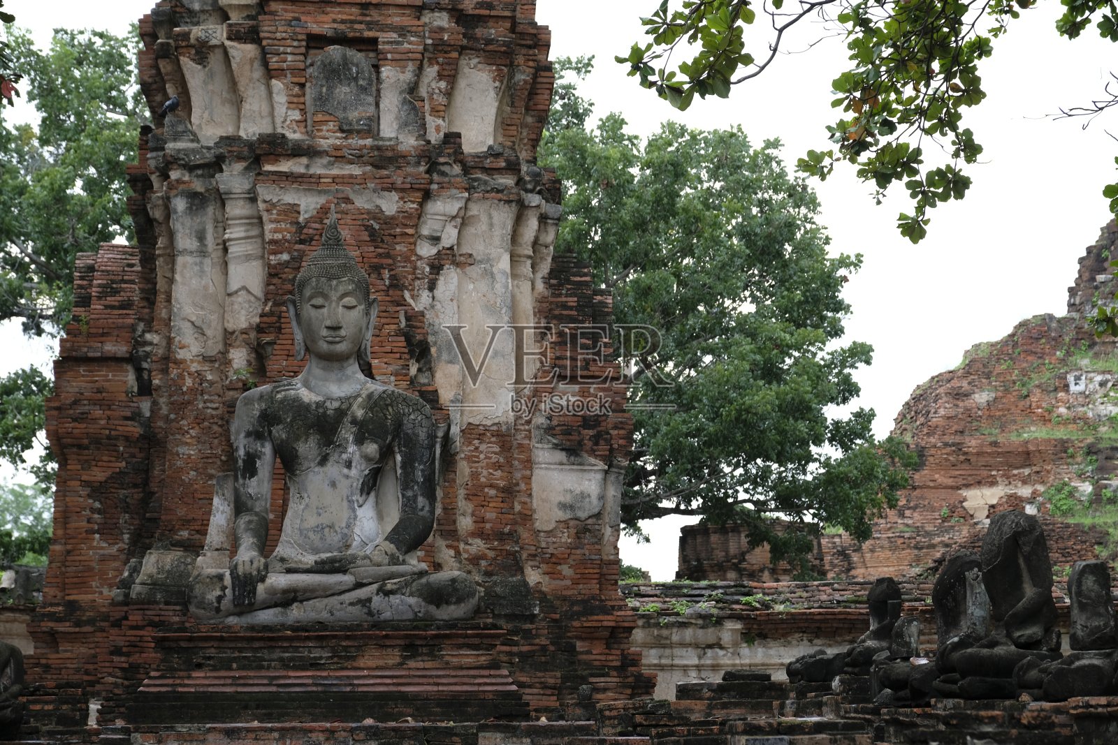 泰国大城府玛哈那寺美丽的宝塔背景下的泰国老佛遗址，泰国。照片摄影图片