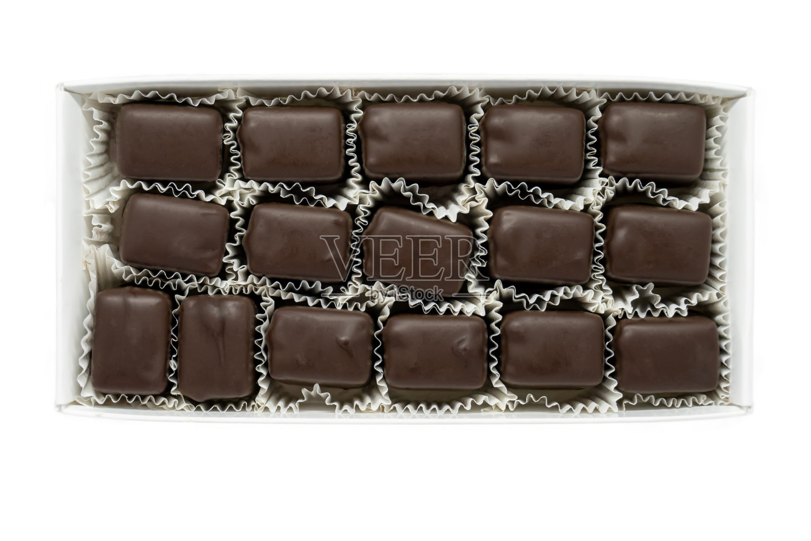 一个长方形的松露巧克力盒被孤立在白色的背景上，象征着吃了一盒巧克力，或者沉溺于甜食。照片摄影图片
