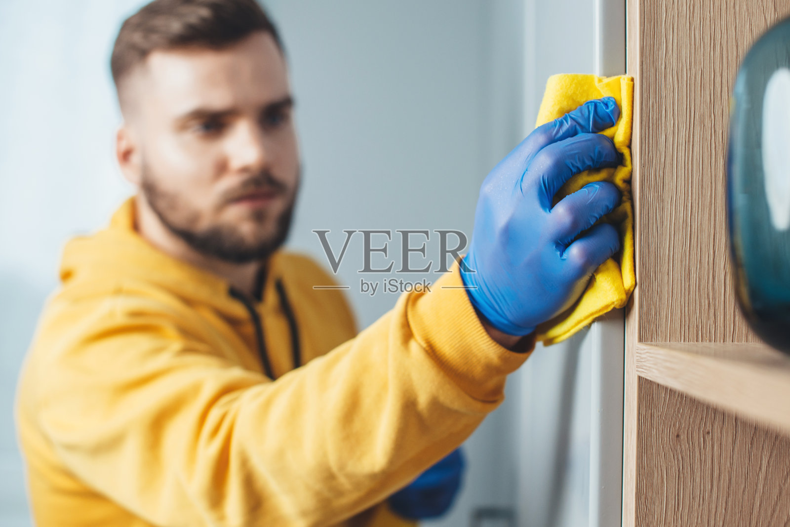 一个留着胡子戴着蓝色手套的白人男子的特写照片正在打扫他的房子照片摄影图片