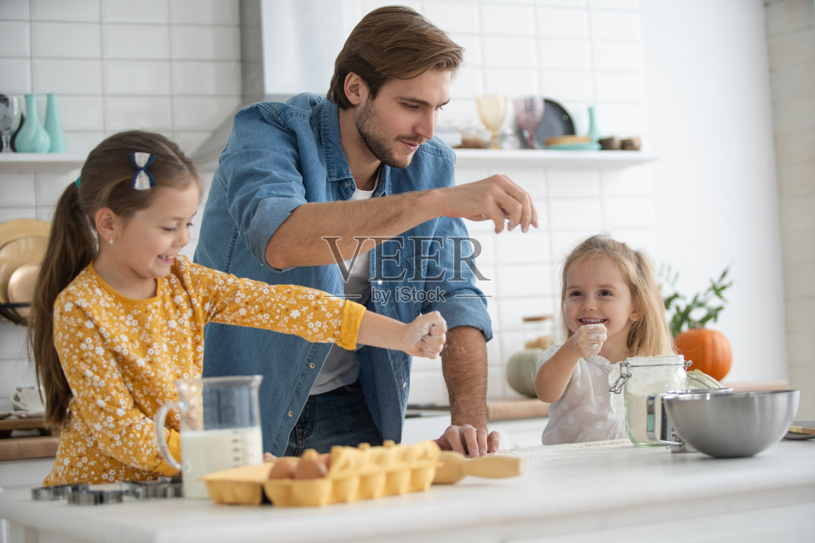 微笑的父亲和女儿在厨房里烤着，玩得很开心照片摄影图片