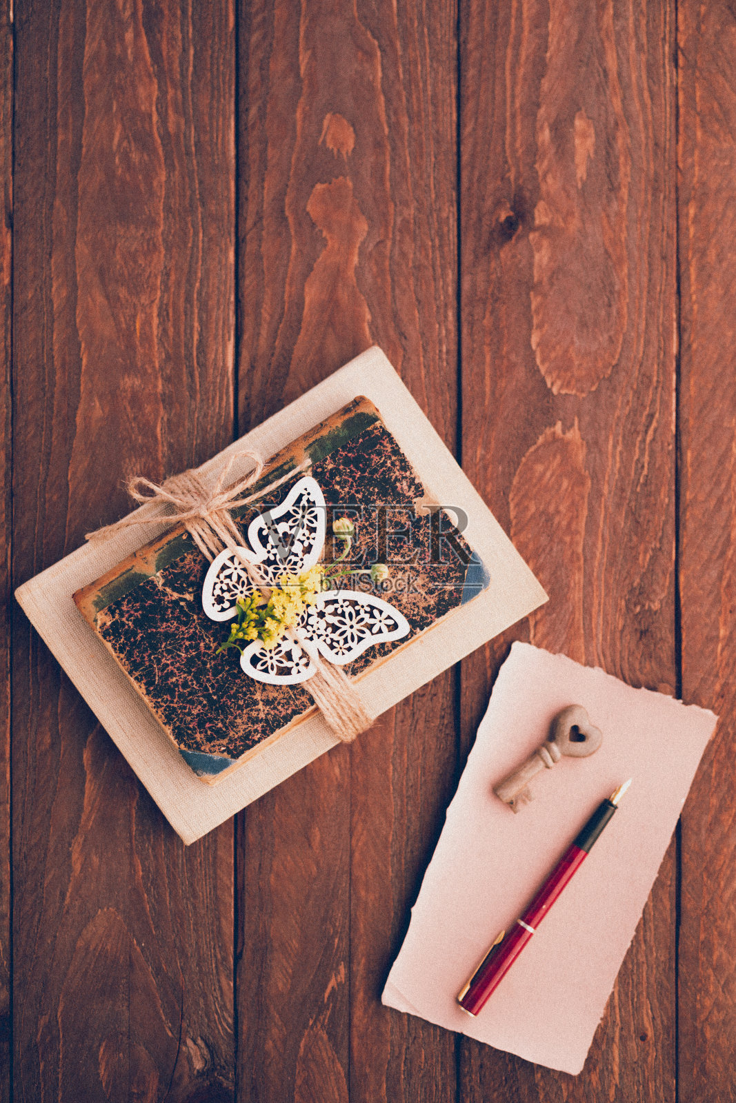 垂直的平面直接从上面以复古的风格放置旧的书籍和鲜花，用空白的手工和乡村纸，顶部有复制空间照片摄影图片