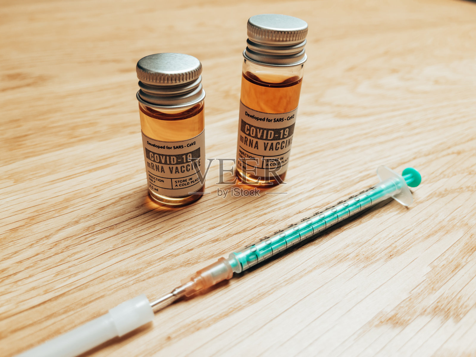 桌上有带注射器的冠状病毒小瓶照片摄影图片