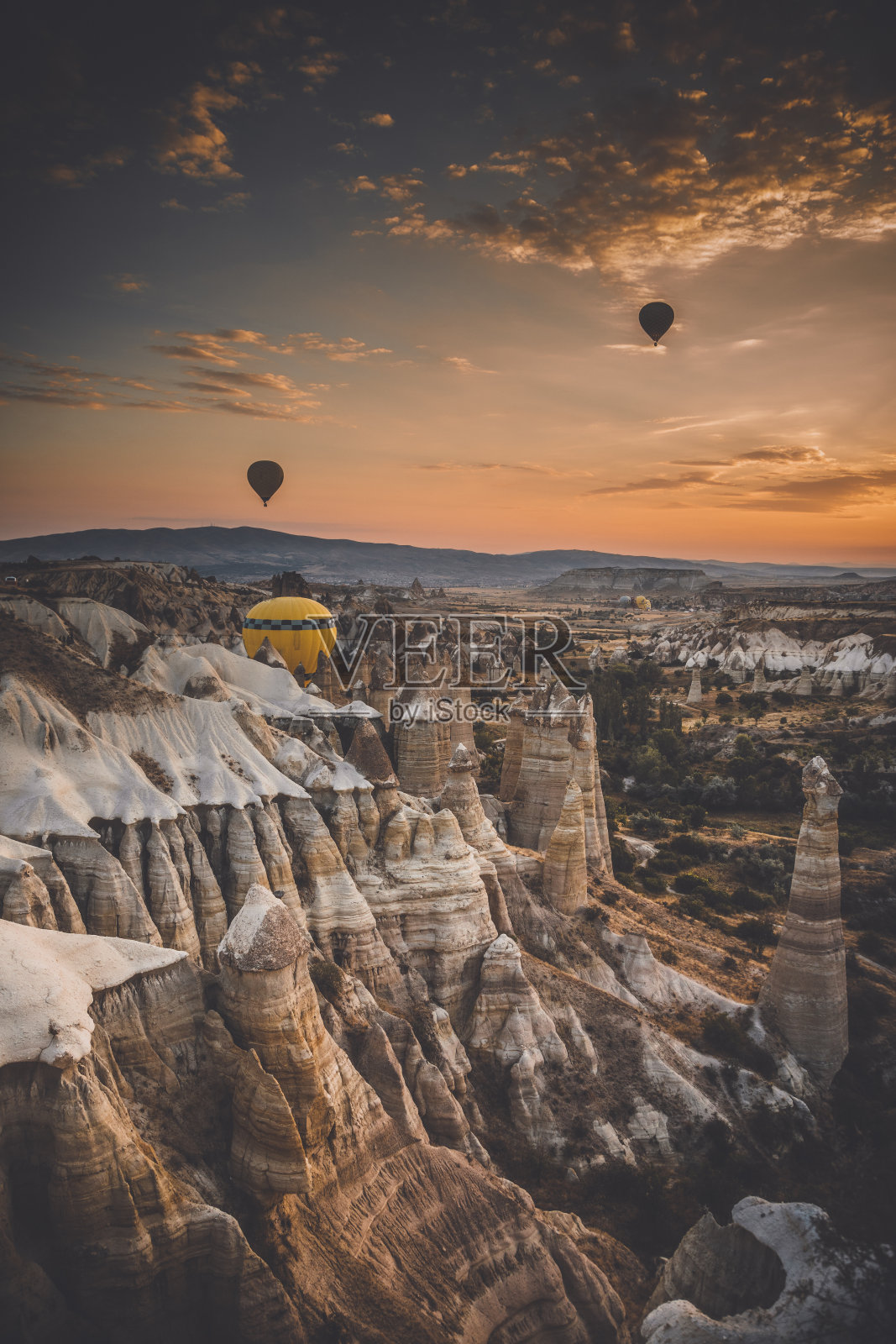 土耳其戈雷米卡帕多西亚，热气球在日出时飞过岩层照片摄影图片