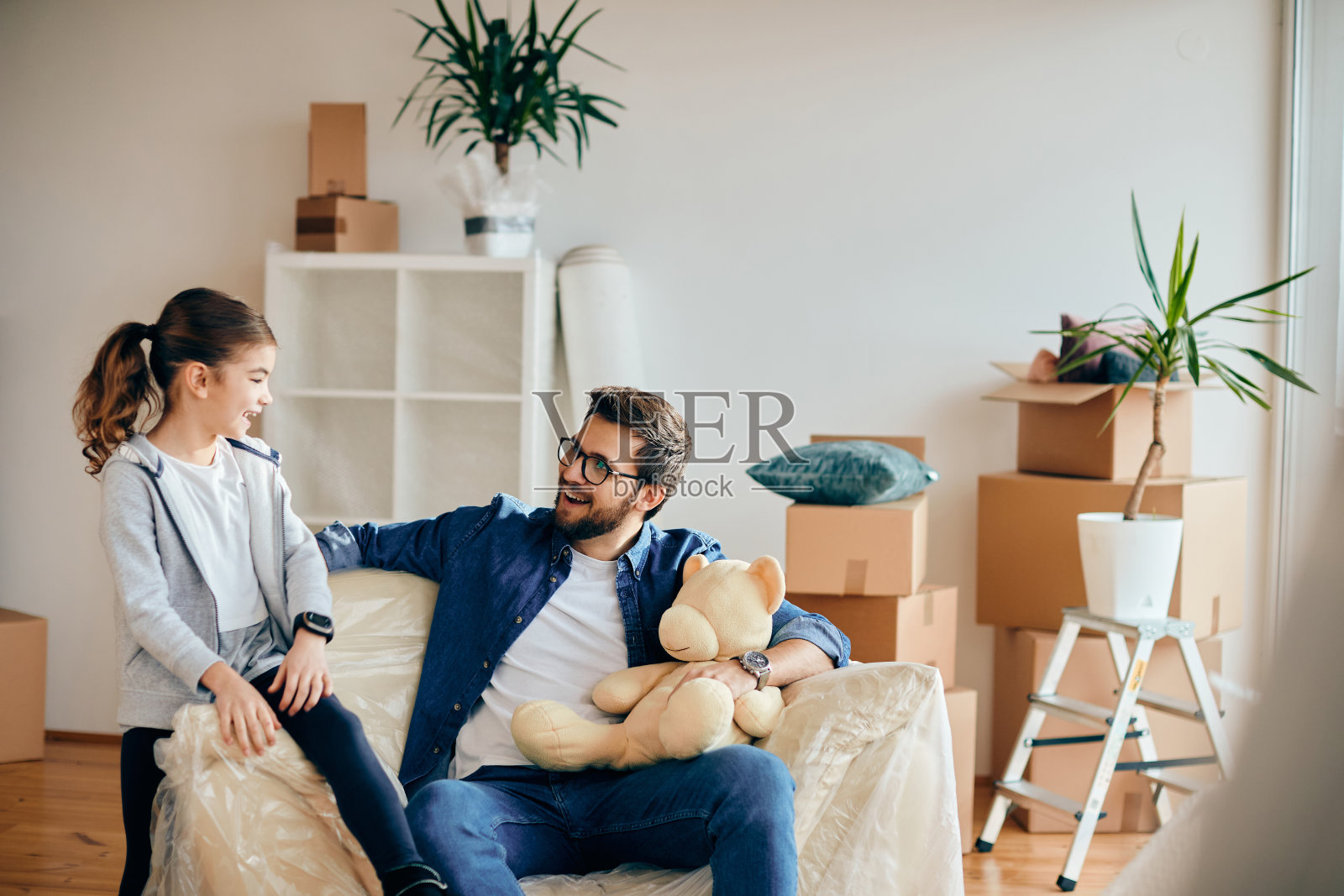 快乐的单身父亲带着女儿搬进新家。照片摄影图片