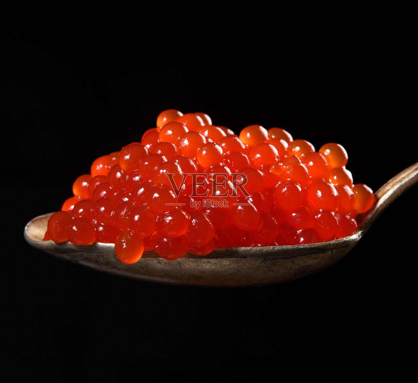 粒状的红色三文鱼鱼子酱放在金属勺子里，美味又健康的食物照片摄影图片