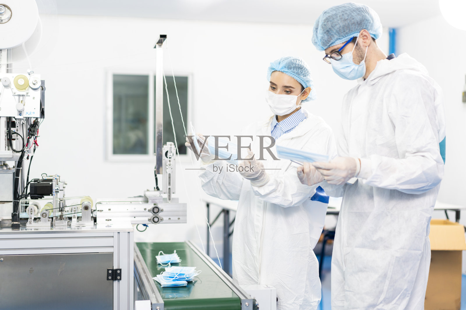 口罩工厂的员工在现代工业机器上检查产品质量。防尘和防毒面具工厂照片摄影图片