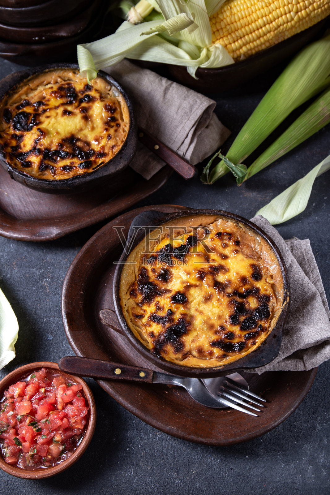 智利的食物。传统的巧克力粉玉米派。牛肉与洋葱，鸡肉和鸡蛋覆盖在土碗玉米碎，俯视图照片摄影图片