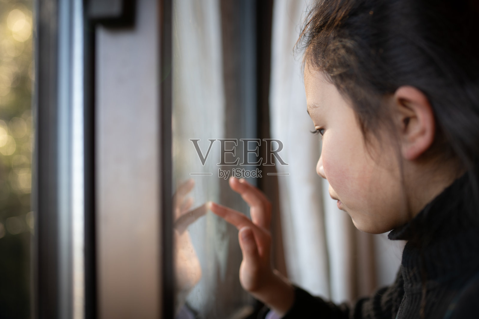 女孩碰着窗户玻璃照片摄影图片