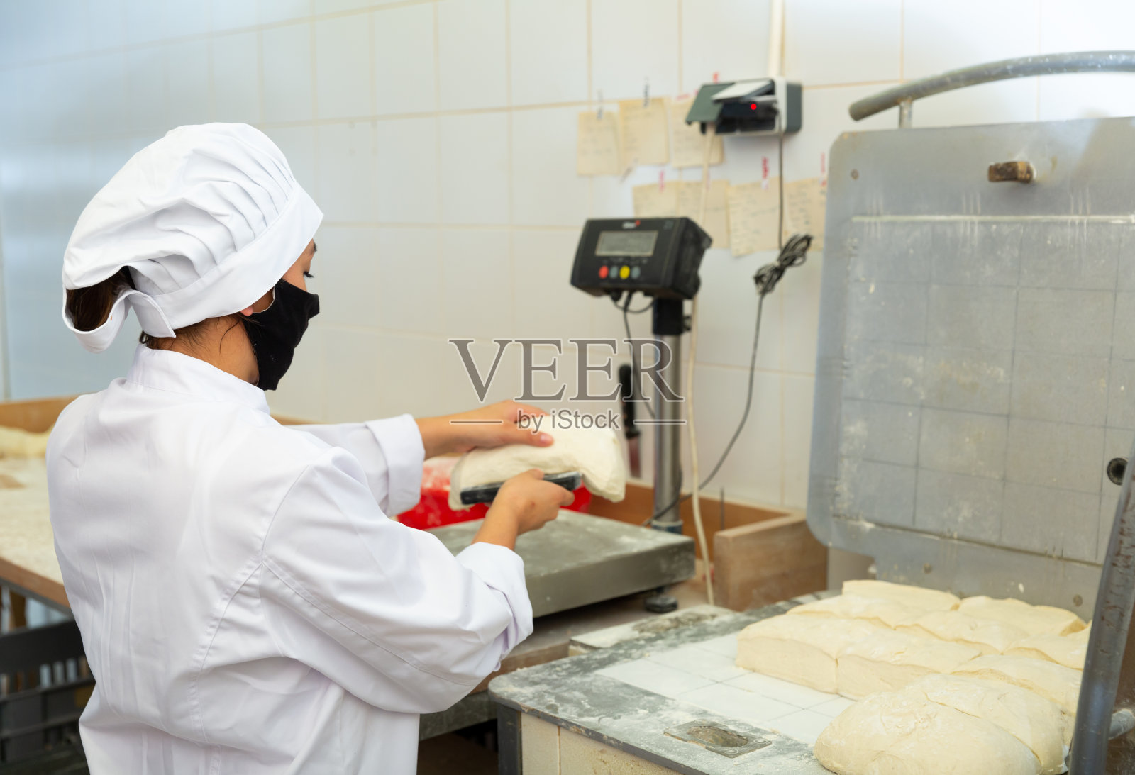 女面包师分面团并称重照片摄影图片
