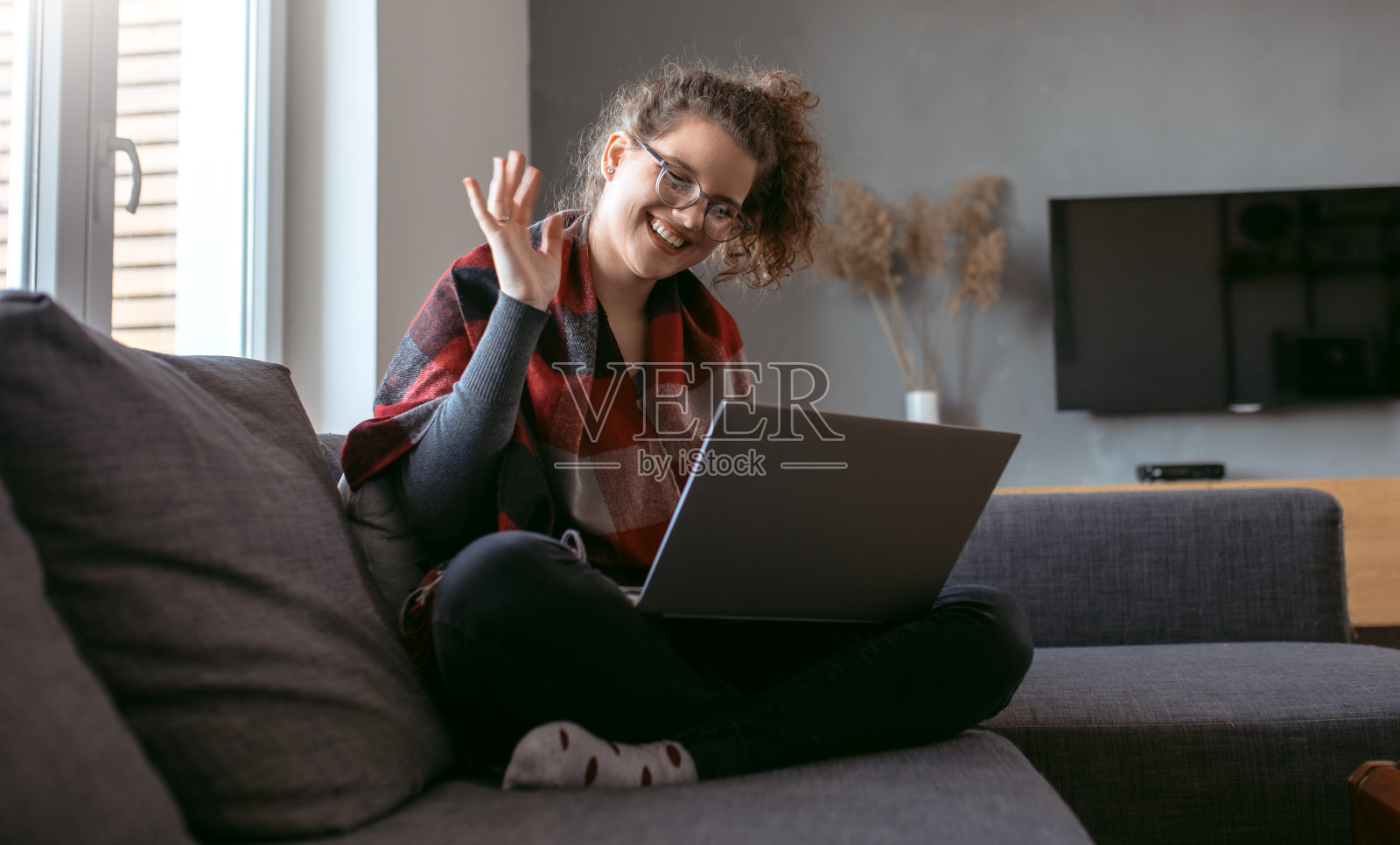 年轻妇女在家工作。年轻的女商人用手提电脑工作。在家工作的女商人。照片摄影图片