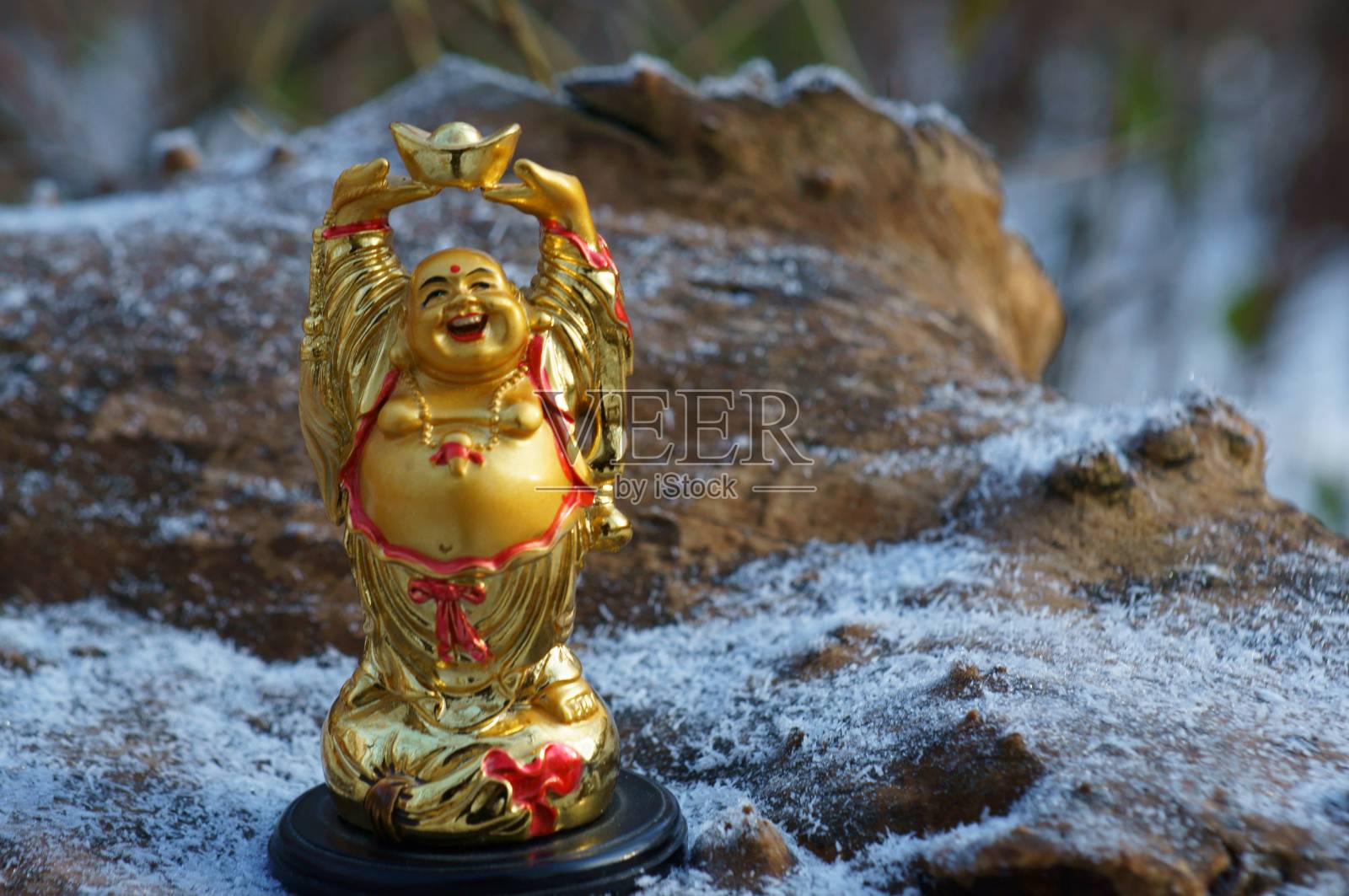 佛像在一个木制的背景覆盖着细雪。照片摄影图片