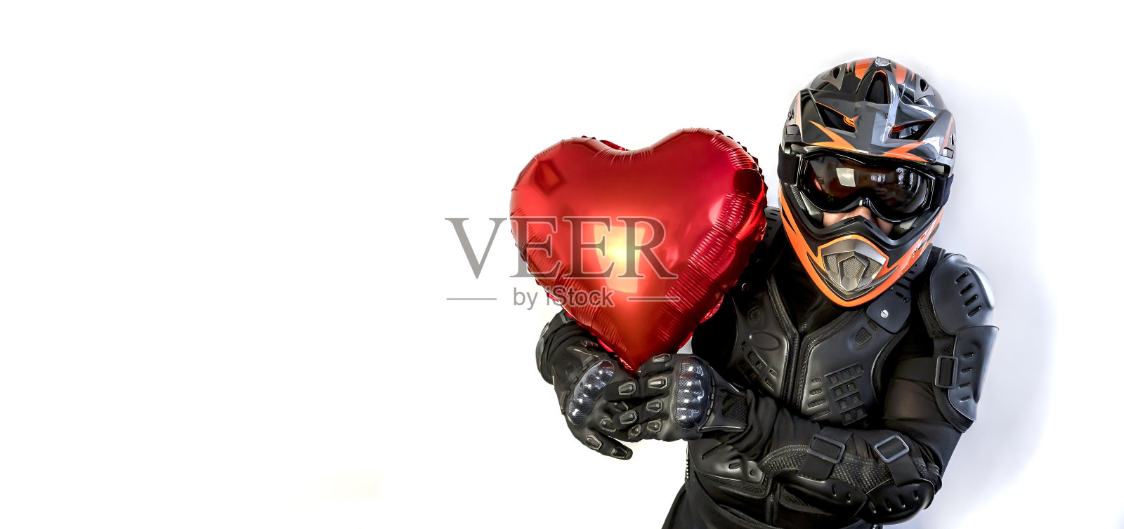 情人节快乐!情人节那天，一个戴着气球心脏头盔的移动摩托车手照片摄影图片