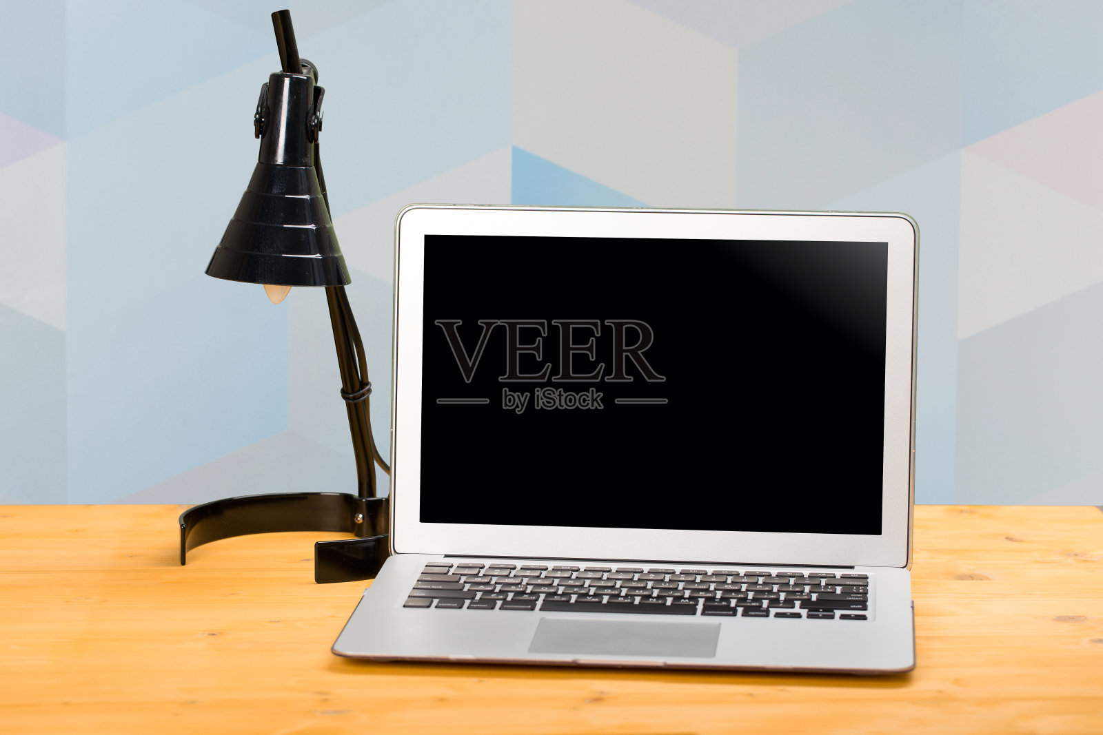 笔记本电脑与空白屏幕的产品显示在办公室和黑色台灯“n现代模糊的背景照片摄影图片