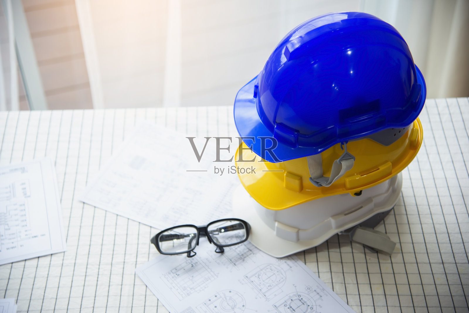 在混凝土地面上，为工程师或工人安全工程提供白色、黄色和蓝色的硬质安全帽。工业照片摄影图片