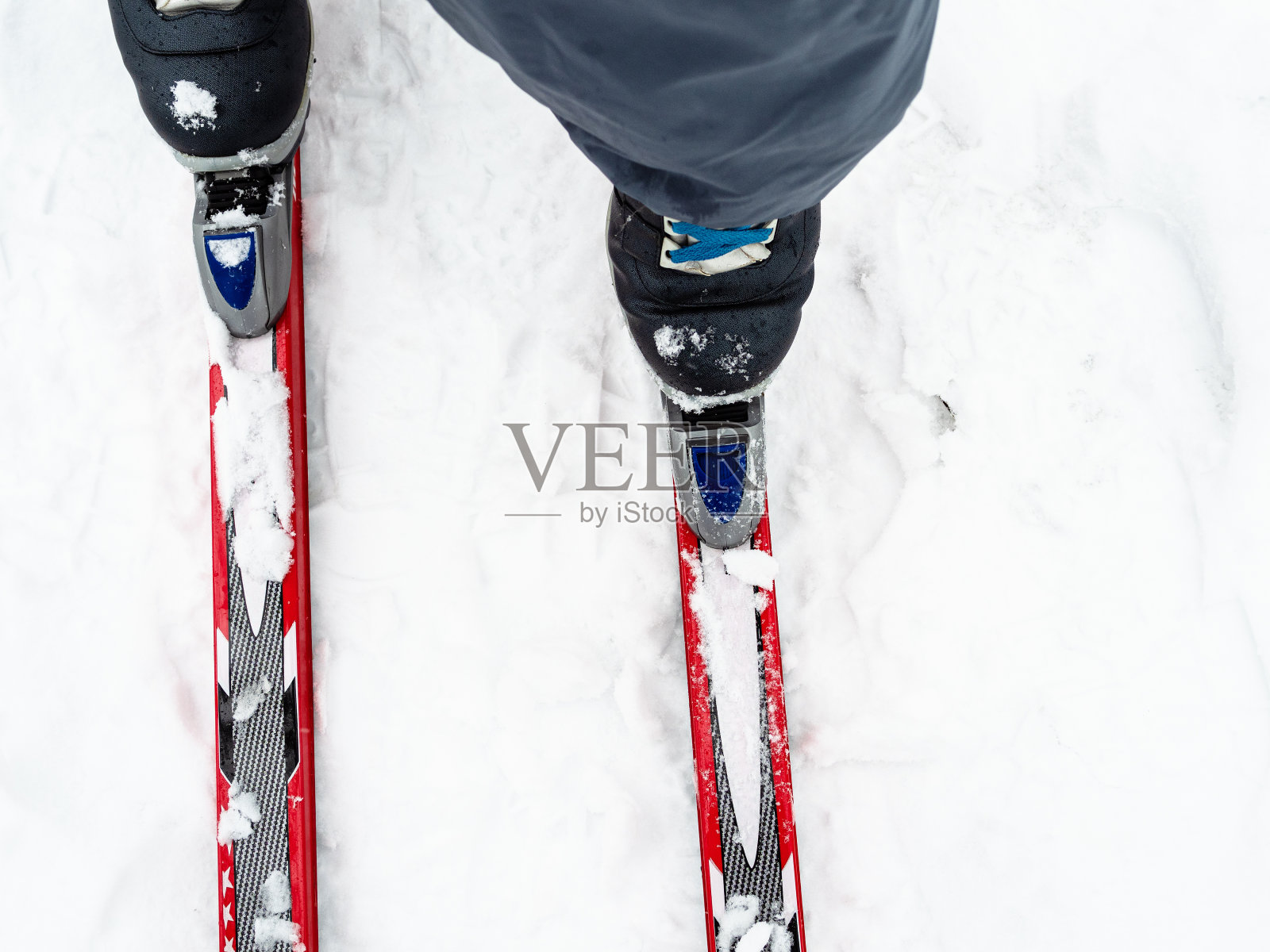 雪上滑雪者系紧滑雪板鞋的俯视图照片摄影图片