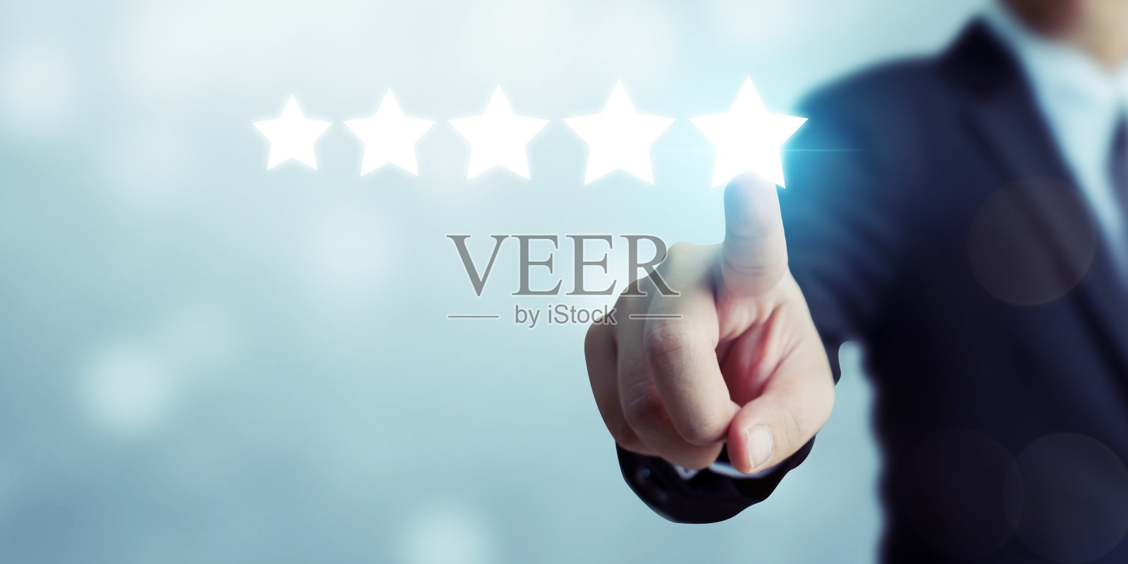 商人指着五星标志提高公司的评级照片摄影图片