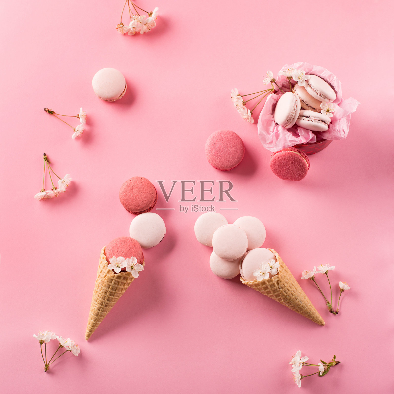 礼品盒里的玫瑰杏仁饼干，樱花，空信封。甜马卡龙呈现在粉红色的背景。照片摄影图片