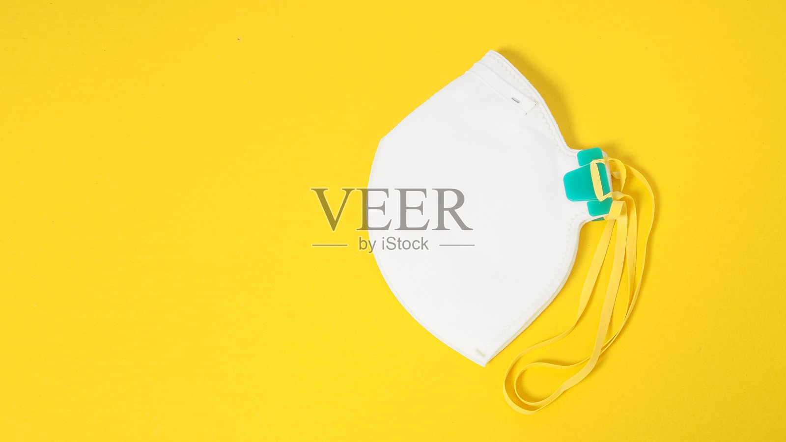 用橡胶材料制成的防护病毒的白色黄底色N95口罩和头带。照片摄影图片