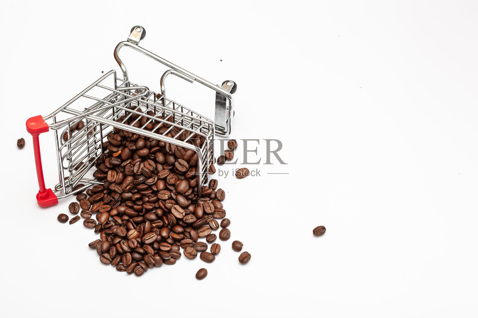 在白色孤立的背景下，翻倒的超市手推车上放着咖啡豆照片摄影图片