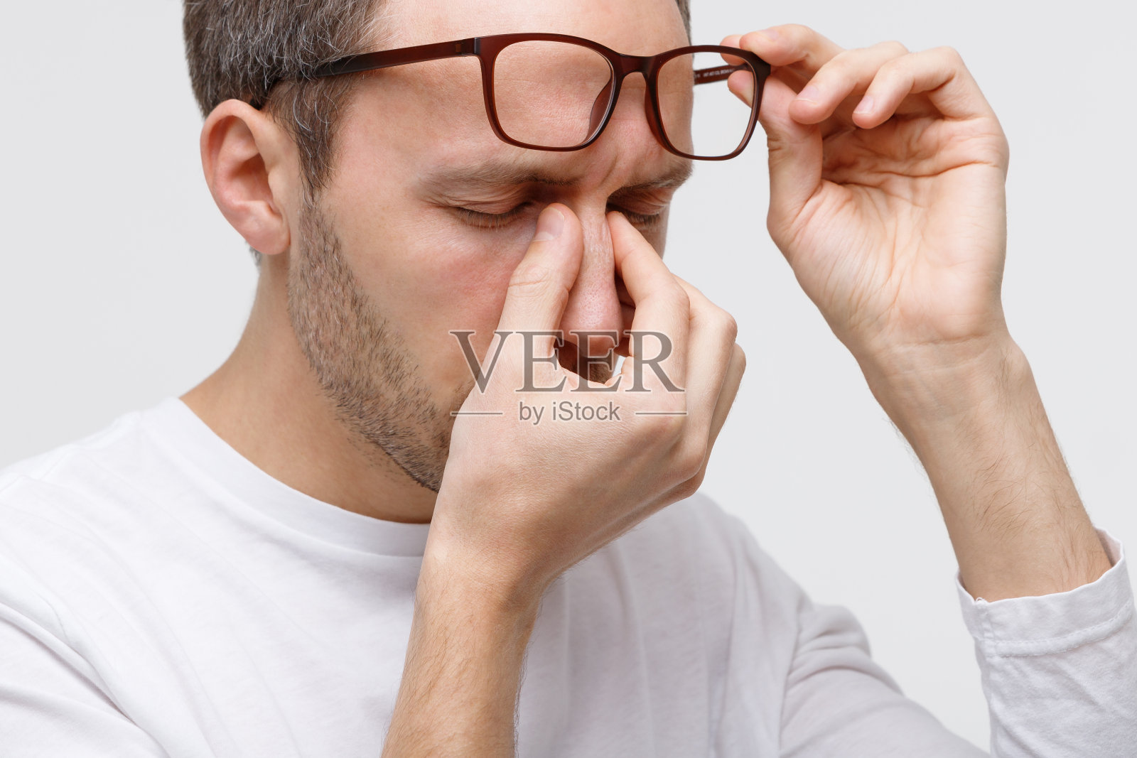 戴眼镜的男人摩擦鼻梁，感觉很累照片摄影图片