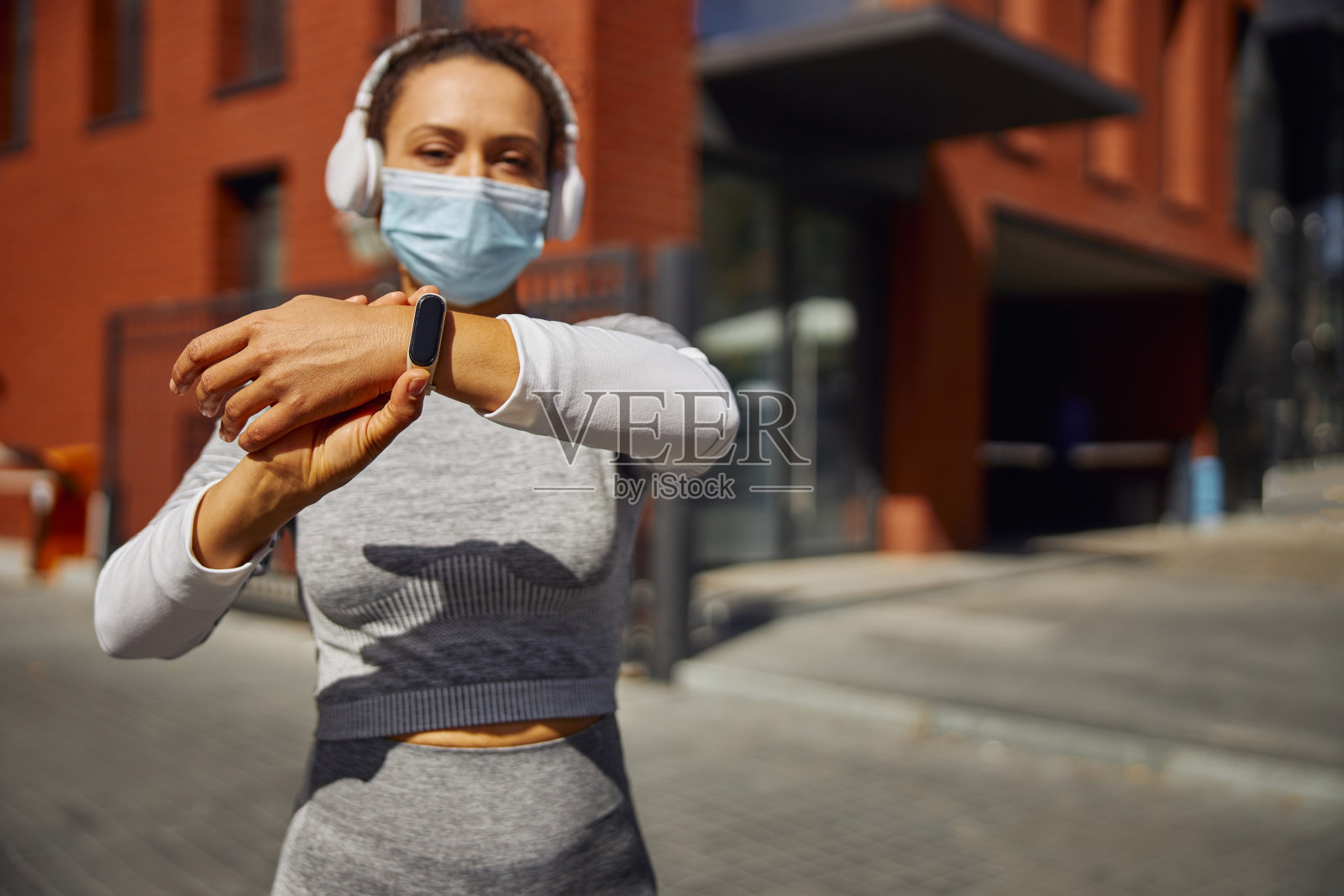 美丽、健康、快乐、微笑的女人在城市街道上锻炼照片摄影图片