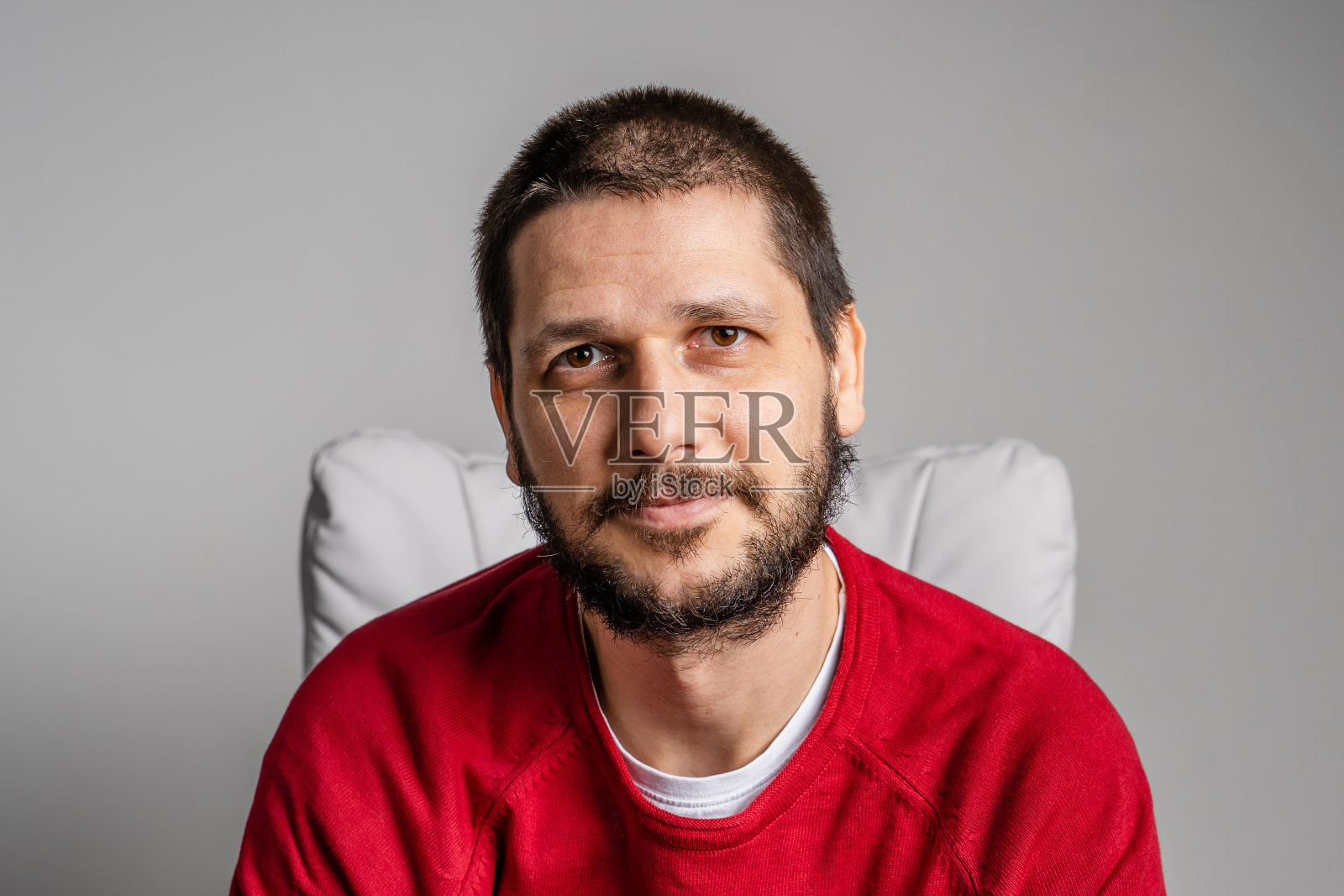 正面特写的成年白人男子的胡子和深棕色的头发看着镜头-乐观的喜悦在男性脸上坐着照片摄影图片