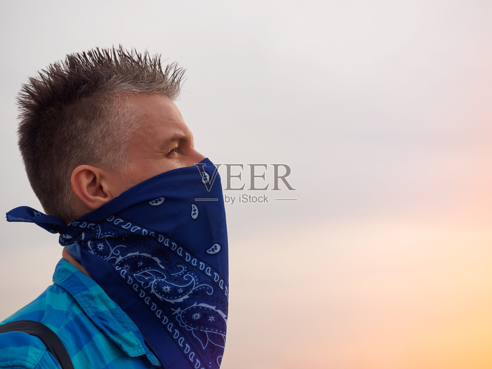 一个白人男子的肖像，他的脸被蓝色的头巾覆盖照片摄影图片