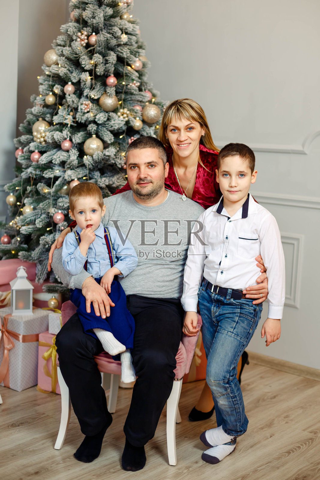 欢乐的人们在沙发上摆姿势拿礼物。快乐的父母,孩子照片摄影图片