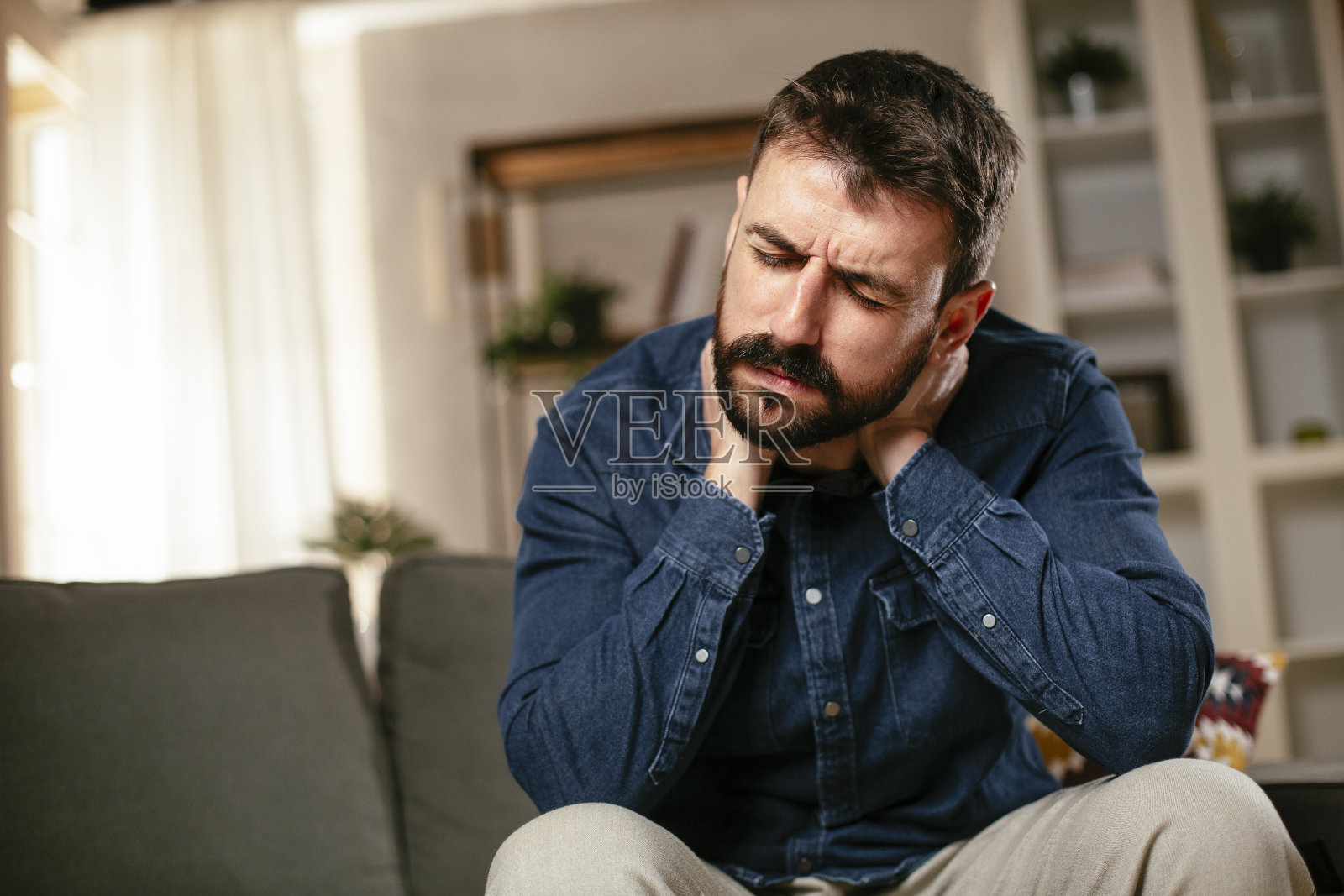 年轻人坐在沙发上发烧照片摄影图片