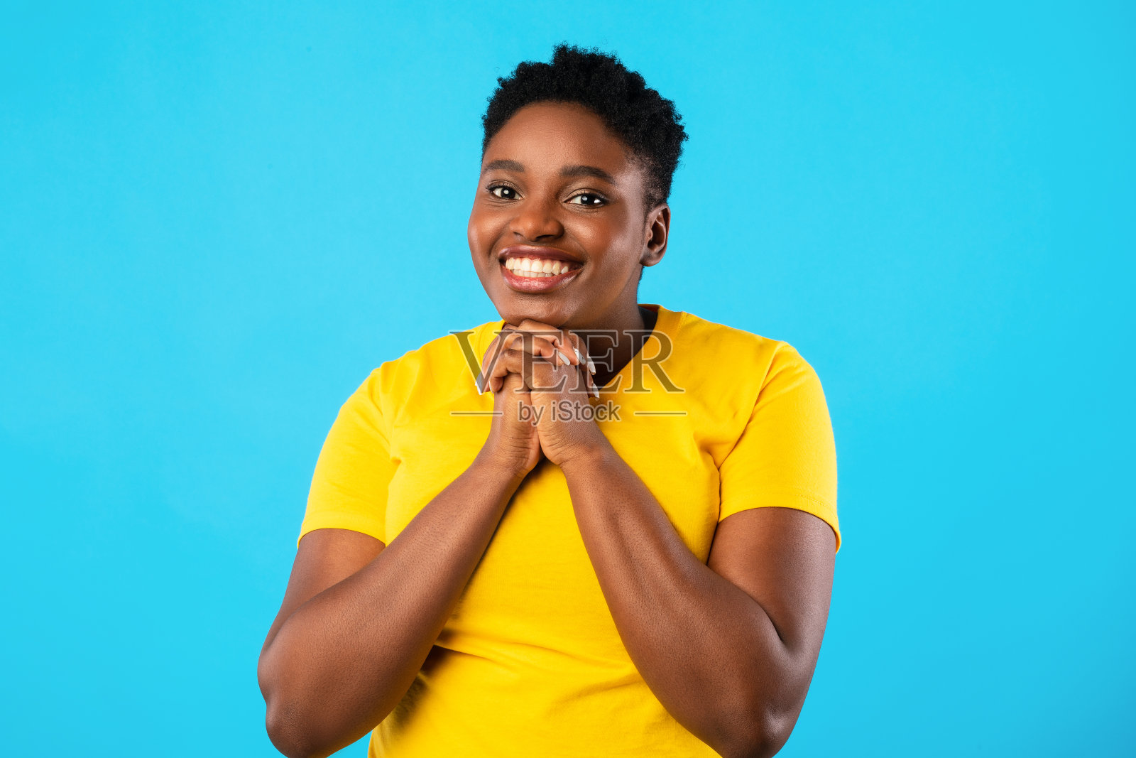 超重的非裔美国女士在蓝色背景上做请手势照片摄影图片