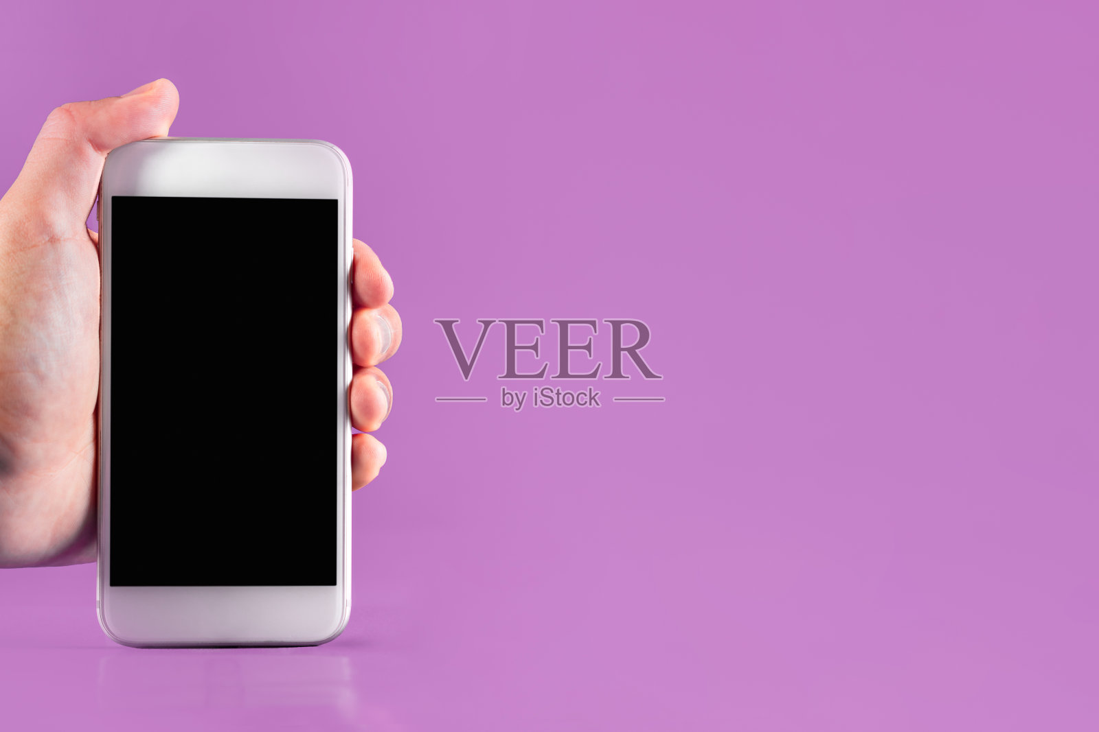 手握现代手机与黑色屏幕的拷贝空间上的粉红色背景。技术和金融概念。照片摄影图片