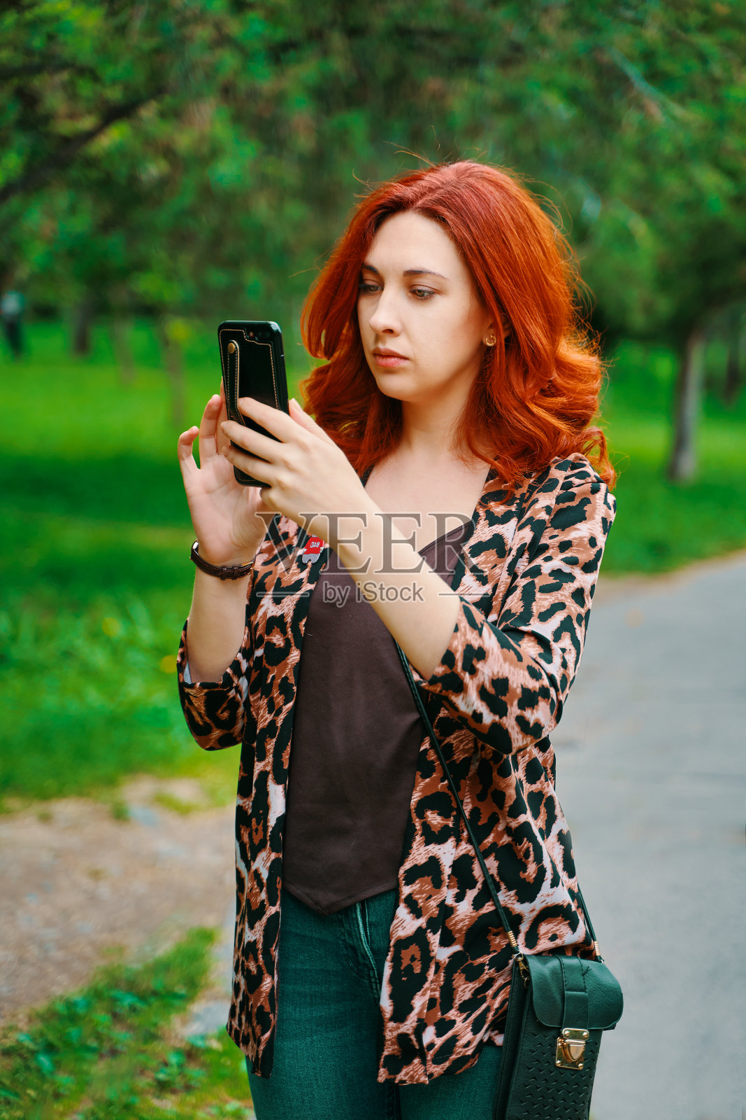 美丽的女孩在看智能手机应用程序中的路线。照片摄影图片