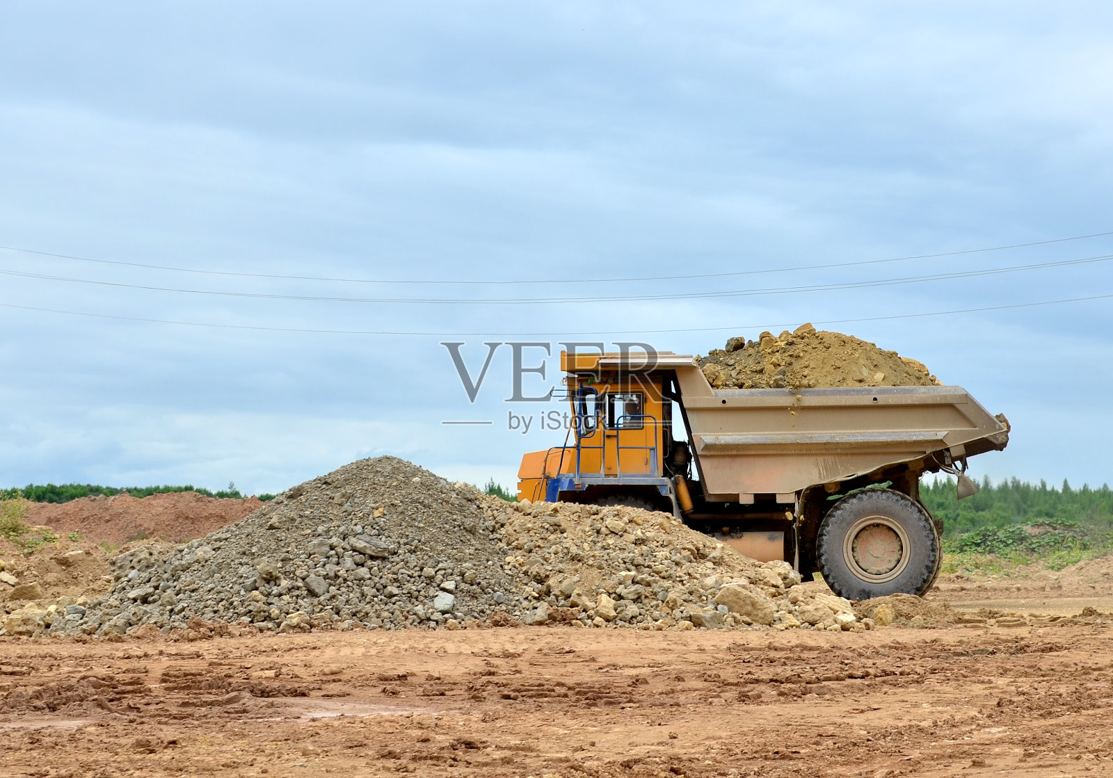 采矿卡车和挖掘机在石灰石露天矿工作照片摄影图片