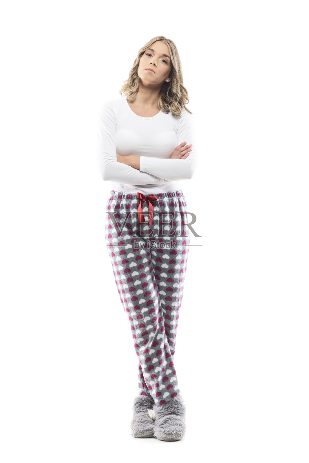 不满的年轻严厉的女人穿着睡衣和拖鞋看着相机不耐烦地等待。照片摄影图片